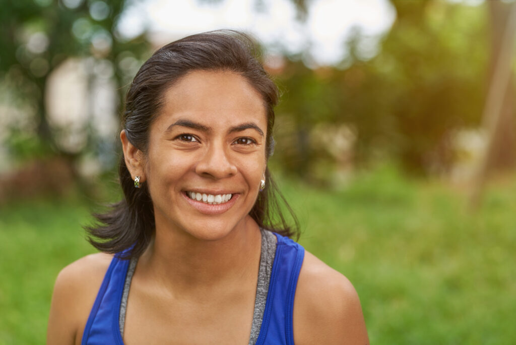 Pretty smiling latina woman in summer park