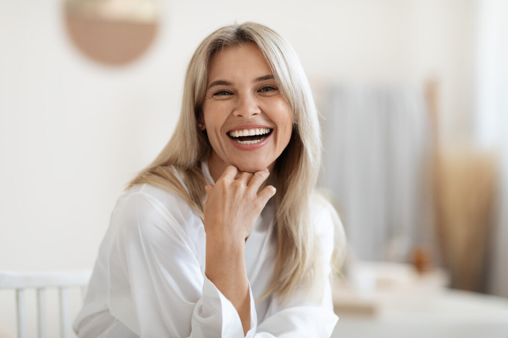 Woman smiling and touching her face