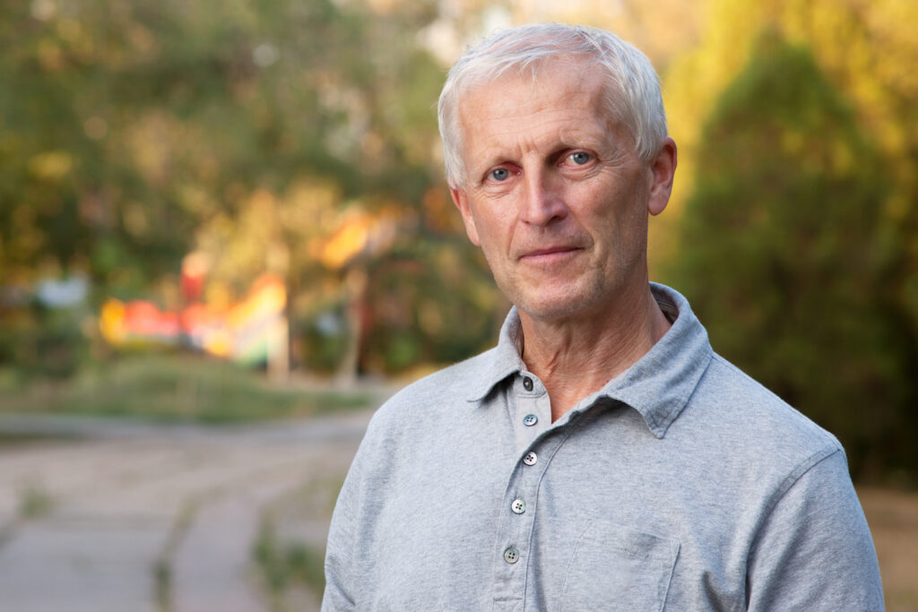 Stern older man standing outside