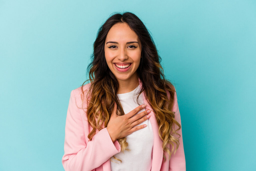 Smiling woman in pink shirt on blue background