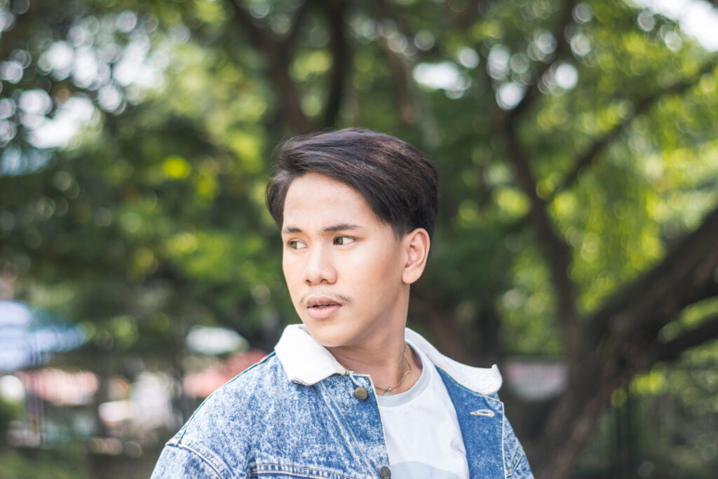 Man in denim jacket standing in profile