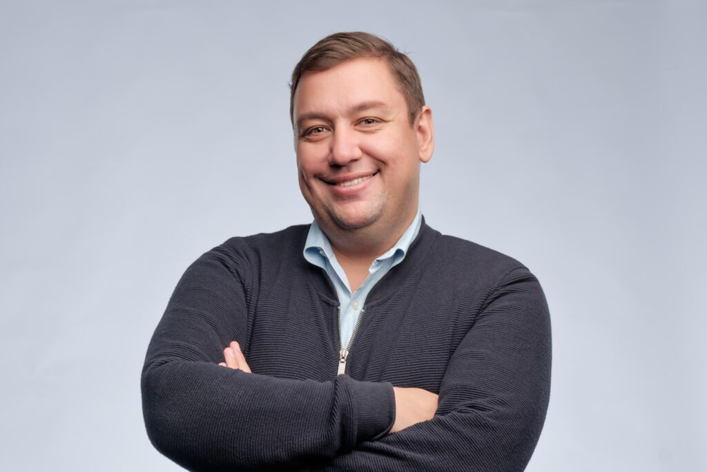 Confident man arms crossed on blue background
