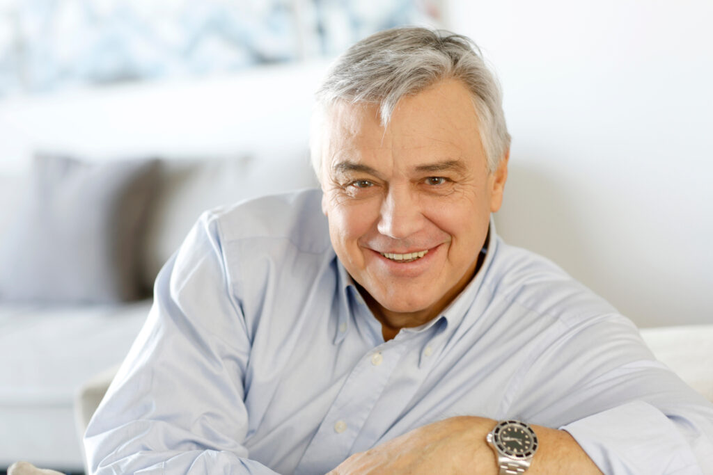 Senior man sitting on a couch smiling